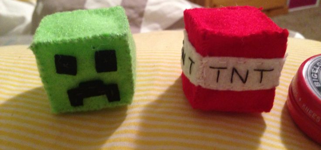 two square minecraft themed plushies, one green zombie and a tnt block