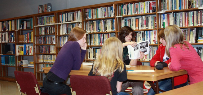 Teen sitting around a table having a meeting.