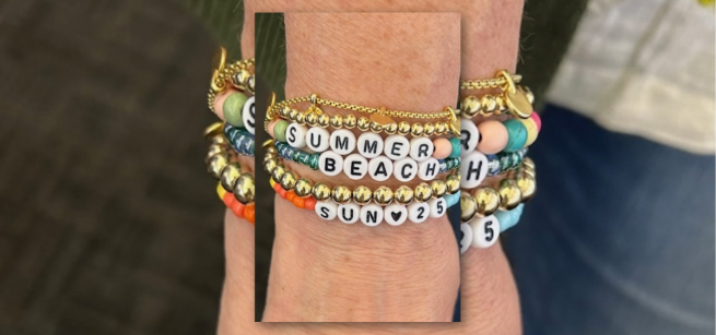 Image of bracelets on a wrist including bracelets with letter beads to spell words.
