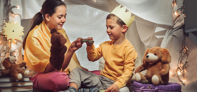 Children playing in a blanket tent
