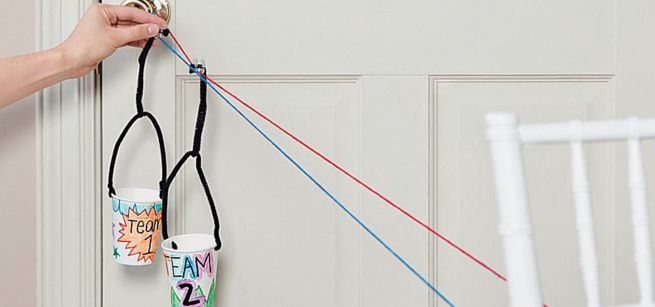 Two simple zipline carriers, made with decorated cups, on a string. 