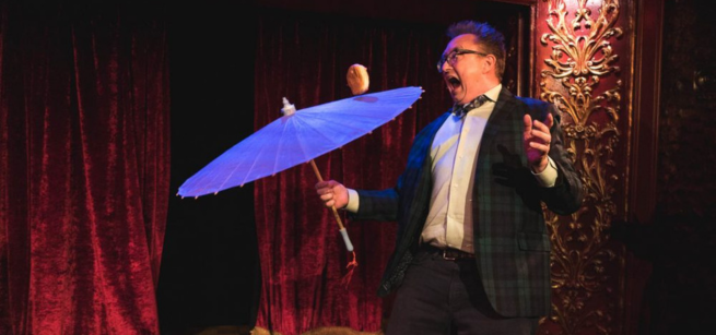 Michael Rayner juggles a cheeseburger on a parasol