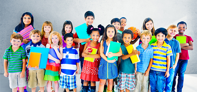 Two rows of children in colorful clothing, holding notebooks, a basketball, an apple.