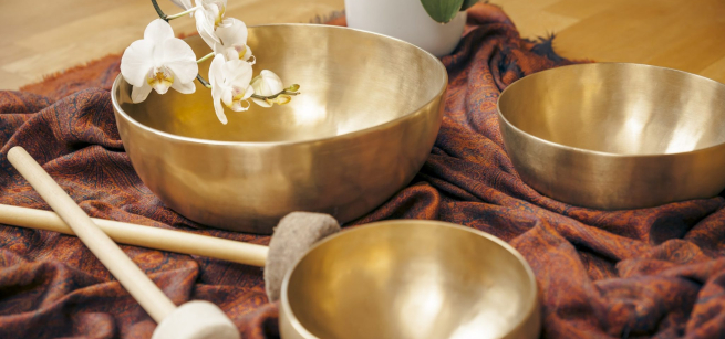 Three golden therapy bowls and white orchid flowers