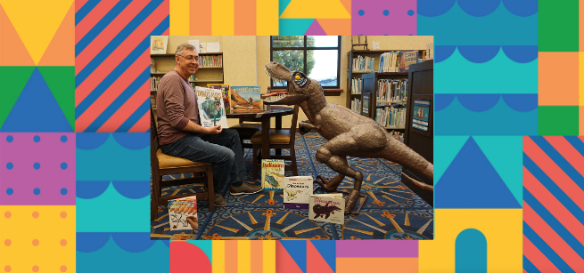 Presenter, Paul and his prehistoric pal, a dinosaur life-sized figure in a library surrounded by dinosaur children books.