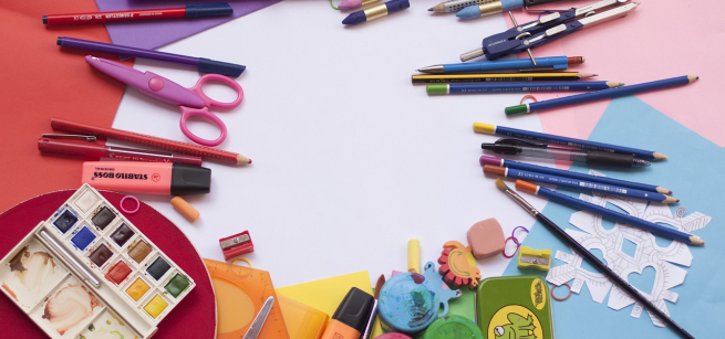 Pencils, pens, scissors, and paints arranged in a circle