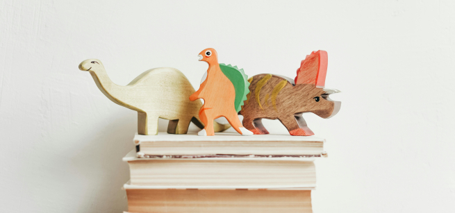 Toy dinosaurs on a stack of books