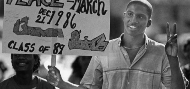 a black teenager holds a protest sign