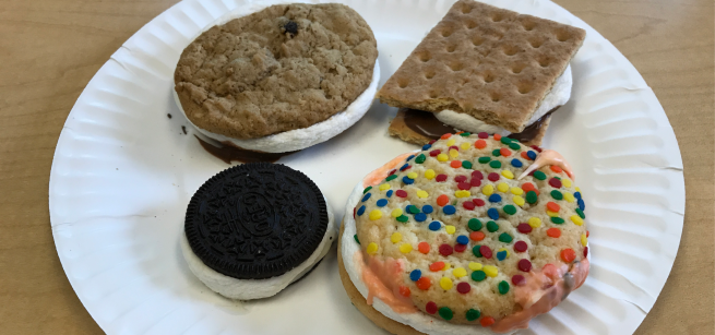 Four s'mores on a plate, one traditional, and three made with various cookies