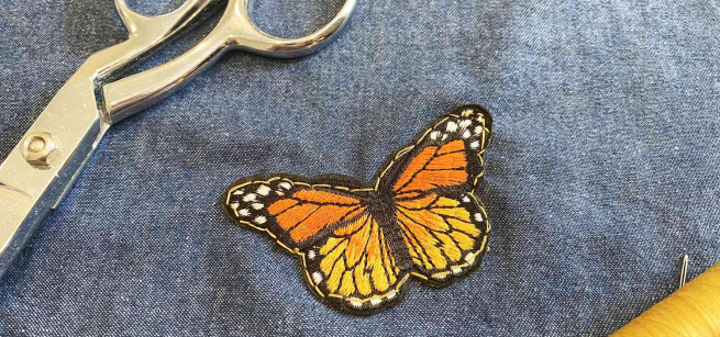 Butterfly patch sewn onto a piece of denim
