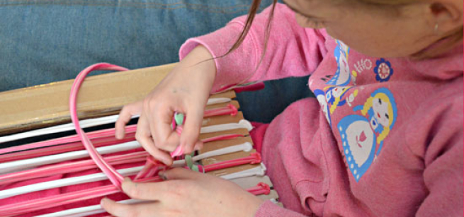Child using old t-shirts to make rug