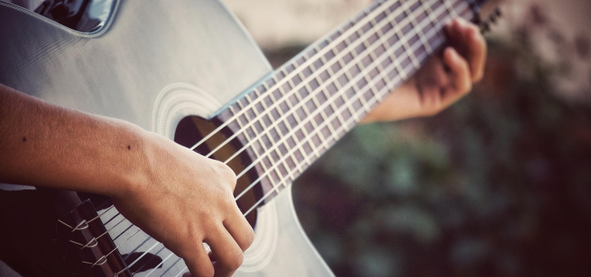 Hands playing a guitar.