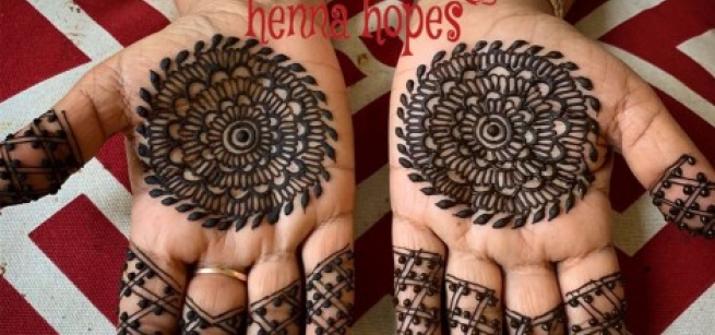 Two upturned hands are shown. Both have elaborate henna tattoos on the palms and fingers.