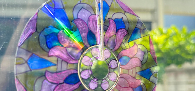 A handmade DVD suncatcher shines with a prism.