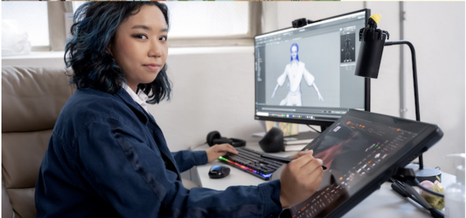 A woman looks over her shoulder as she draws on a tablet to create a video game character.