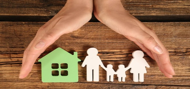 Two Hands covering a house a paper cut out humans