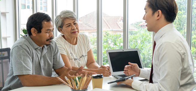 couple sitting at a table talking to an advisor