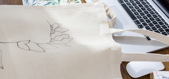Drawing on a canvas tote bag that is laying on desk