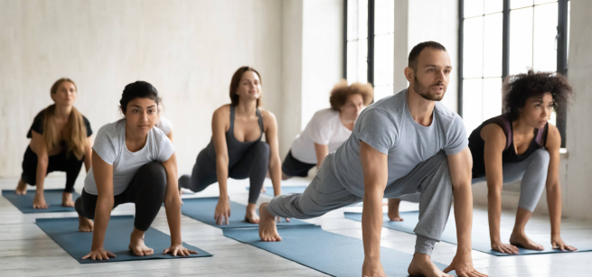 people doing a lunge stretch on yoga mats