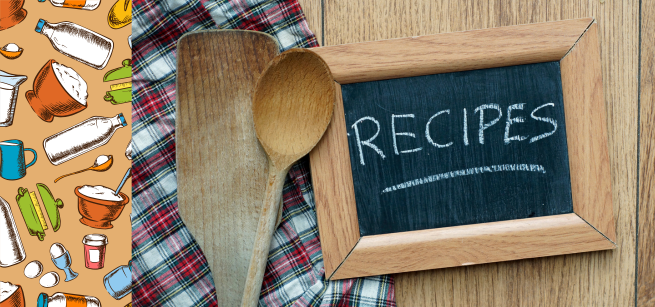 Photo of menu chalkboard with the word recipes and wooden utensils. 