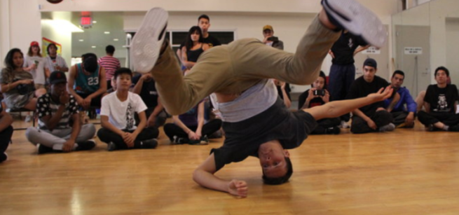 person breakdancing with a crowd watching