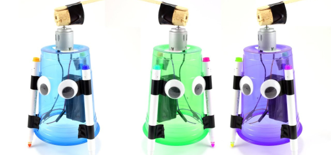 Three art bots, one blue, one green, and one purple stand as finished examples of the activity.