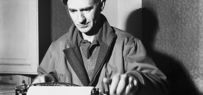 black and white image of Ernie Pyle seated and using a typewriter