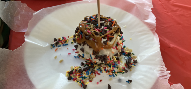 Chocolate and caramel apple with cookie crumbs, nuts, chocolate chips, and sprinkles