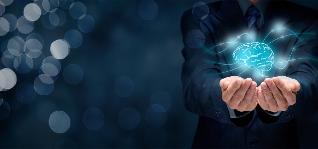 A man in a suit holding out his hands with a digital brain floating above his palms.