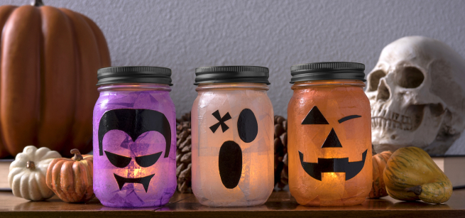 three mason jars decorated to look like a vampire, ghost, and jack o lantern