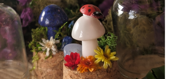 white crystal mushroom with a ladybug on top is surrounded by colorful flowers