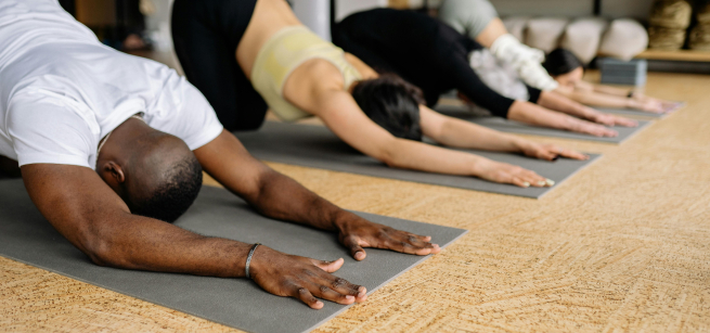 4 people doing yoga in downward dog position 