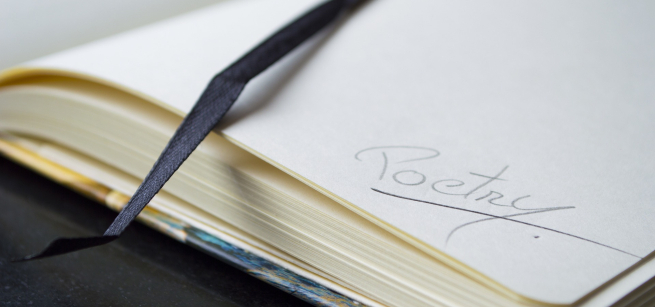 Close up of a page in a journal with the word poetry written on it.