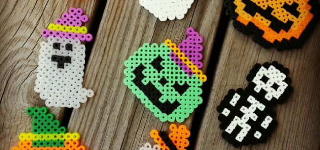 Halloween perler beads craft such as a ghost, pumpkin, and a skeleton 