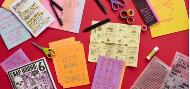 Paper, scissors, pens and paper booklets folded on a red background