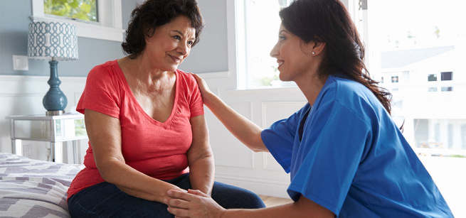 senior and a nurse sitting next to each others 