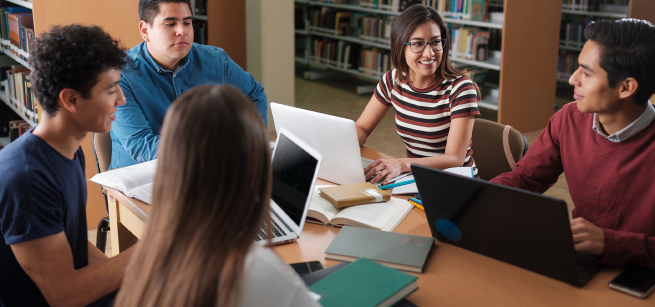 Group of teens studying in the library. 