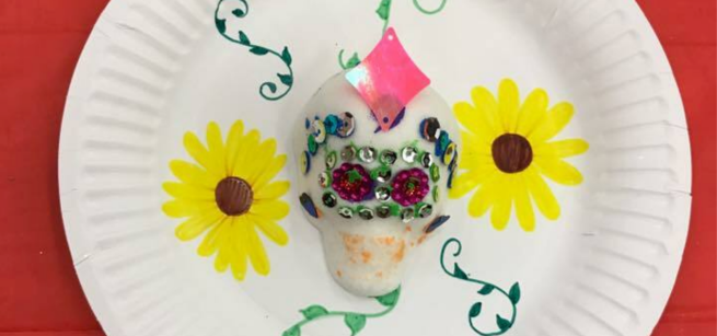 A sugar skull on a decorated plate