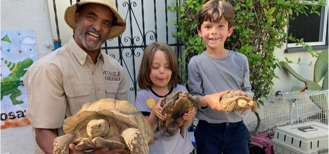Geebo holding a turtle with two kids