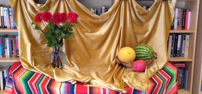 A still life of red flowers and fruits in a basket 