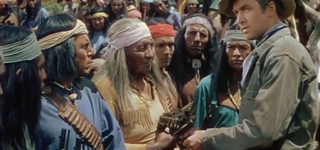 Native Americans in their traditional clothes surround a white settler