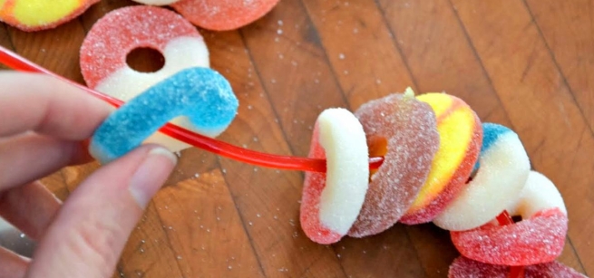 Candy loops being strung into a necklace