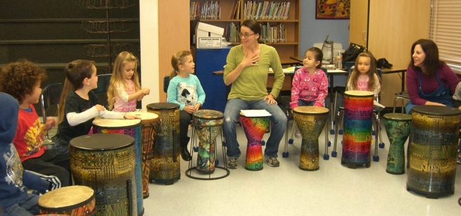 A group of children participating in a drum circle.