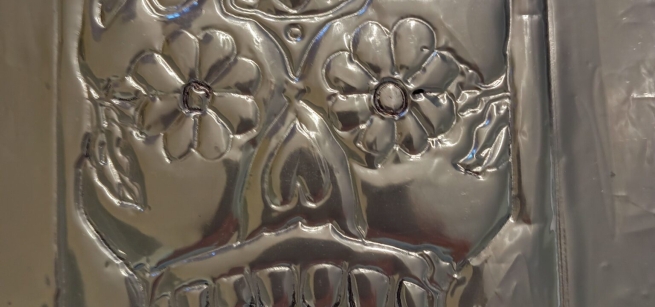 closeup image of a silver skull mask made from tin