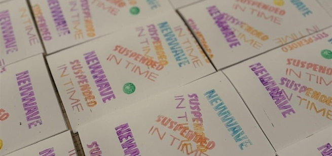 Stamped paper with text "in time, new wave suspended in time"