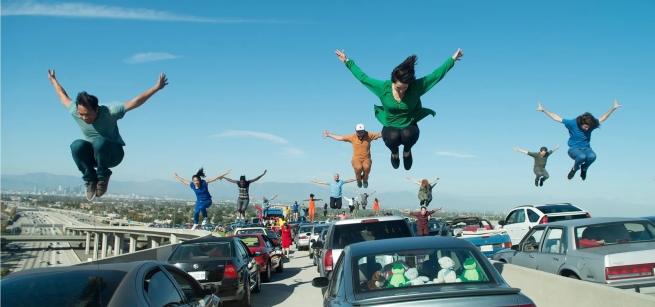 Dancers suspended in jumps above the cars on the 105/110 Interchange 