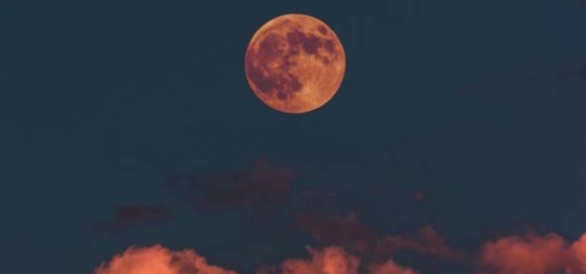 moon on dark night sky with red clouds