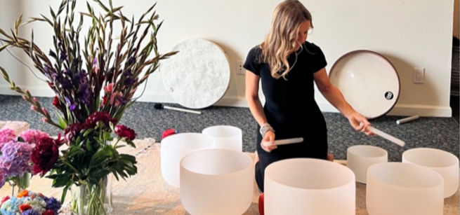 The performer, Heather Nevell, is playing on the glass bawls