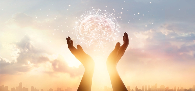 Two hands reach into the sky holding a ball of light