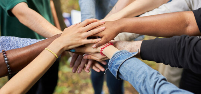 People placing their hands together in a circle